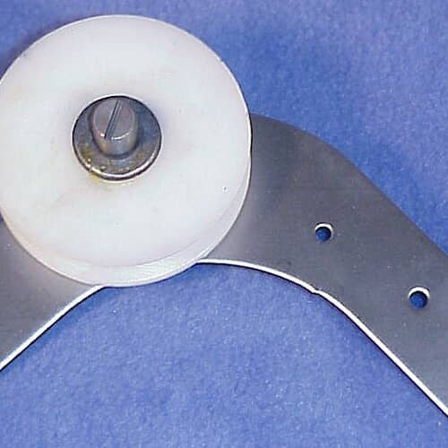 The idler arm assembly shown at an angle on a blue textured surface, with the metal arm curving downward.