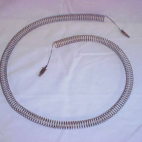 The coiled metal heating element resting on a light purple/blue surface, showing the wiring connectors.