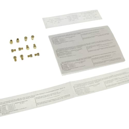 A kit containing a set of brass gas orifices aligned next to a white instruction packet.