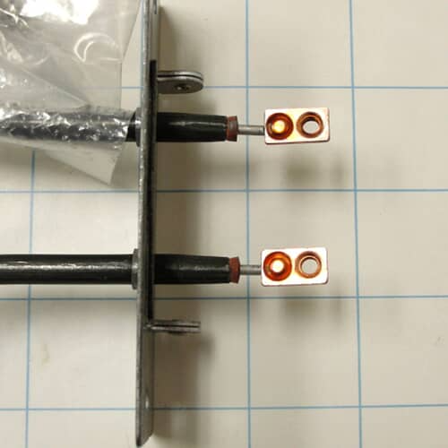 Black heating element with terminals and mounting plates at both ends.