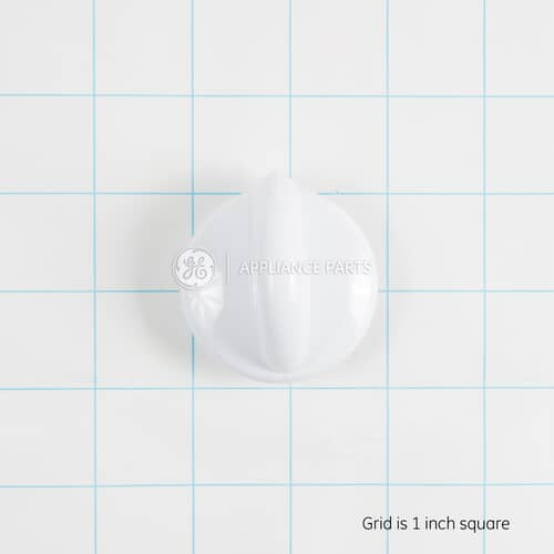 Top-down view of the white surface burner knob on a grid for size reference.