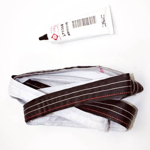 Top view of the dryer felt seal kit showing the light fabric, black stripe, and adhesive tube