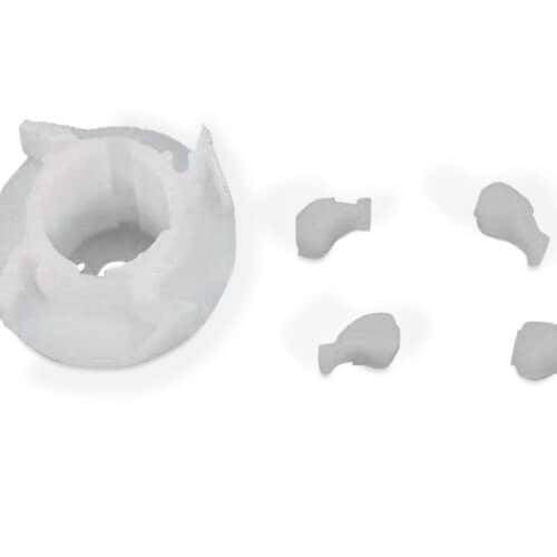 Close-up of the white agitator cam separated from the four black clips against a grid