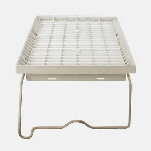 Three-quarter view of the white plastic dryer rack assembly with its beige/tan metal support legs attached.