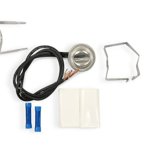 Close-up of the silver disc-style bi-metal defrost thermostat with electrical wires and insulation.
