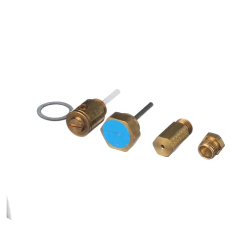 A collection of brass orifices, a white/blue-capped regulator, and a rubber washer from the LP conversion kit laid out on a white surface.