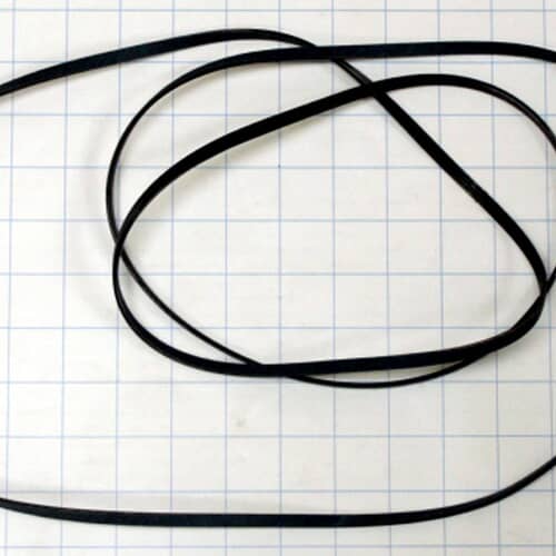 The black dryer belt laid out on a white grid background for scale reference.