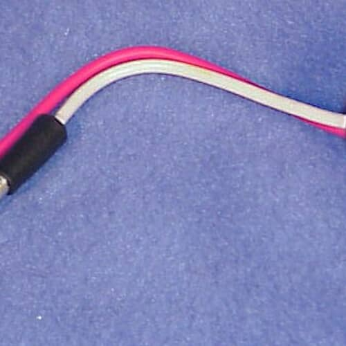 A view of the defrost thermostat showing the long wire leads (red and white) and the black sensor bulb extending from the metal cap.