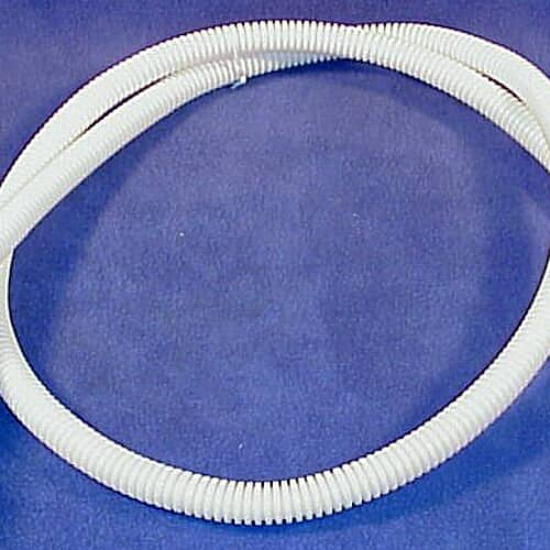 The GE dishwasher drain hose coiled on a dark blue/purple surface