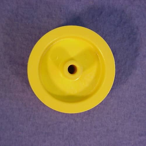 Top view of the bright yellow GE idler pulley against a purple background